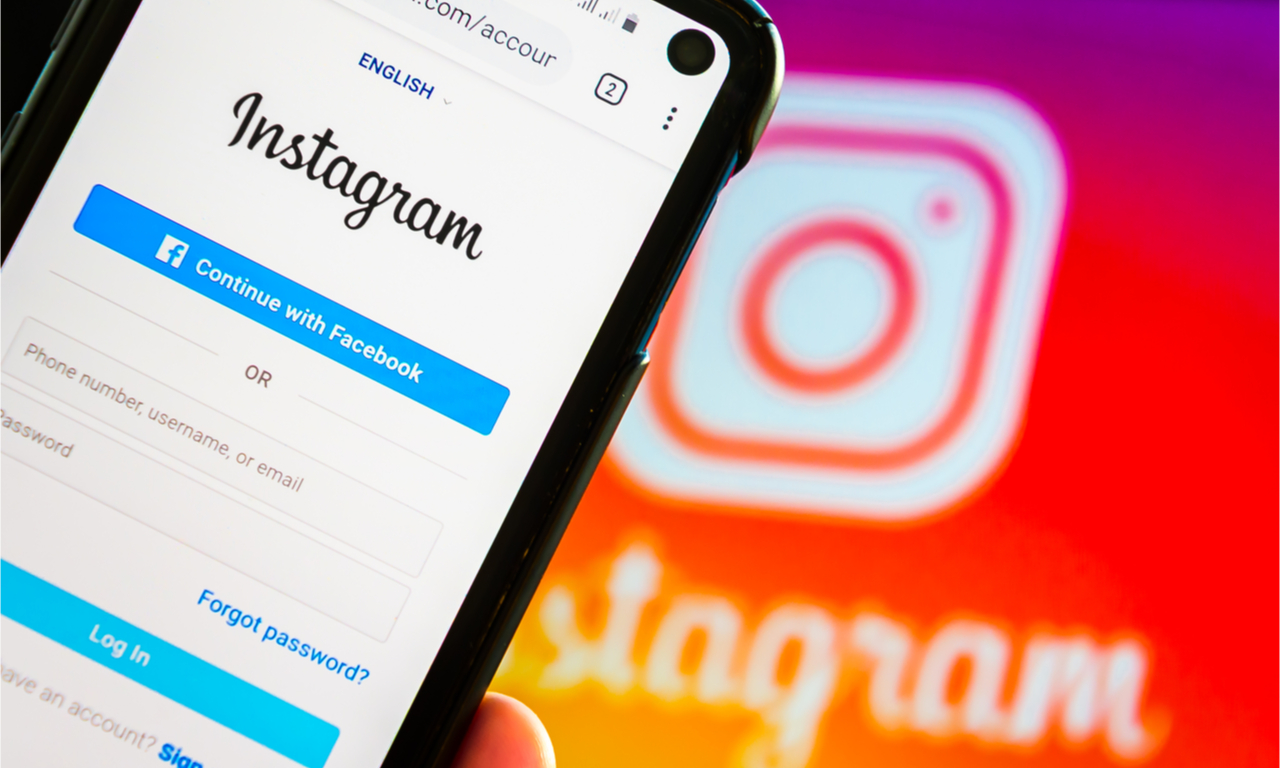 mobile phone on instagram login page with instagram banner in the background