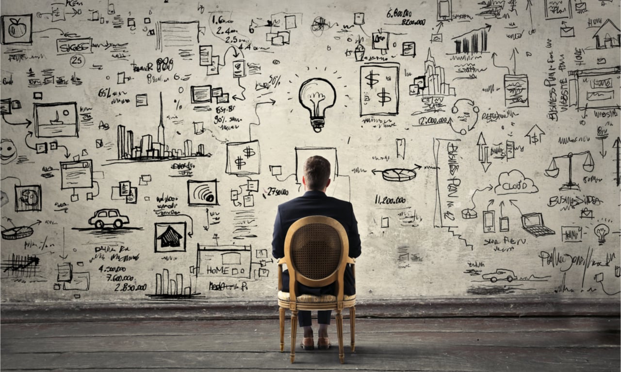 man sitting in a chair looking at a drawing board of ideas for lead generation