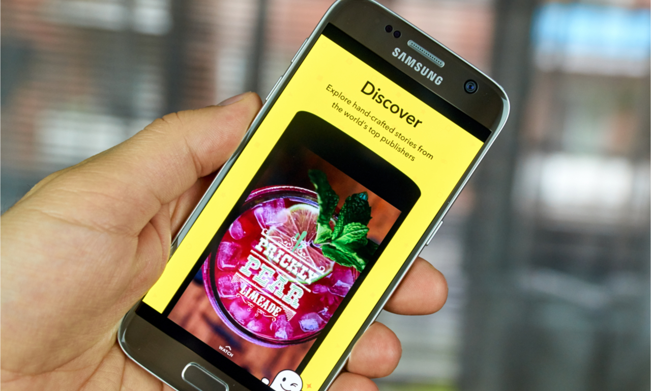 someone holding a samsung phone showing a snapchat ad